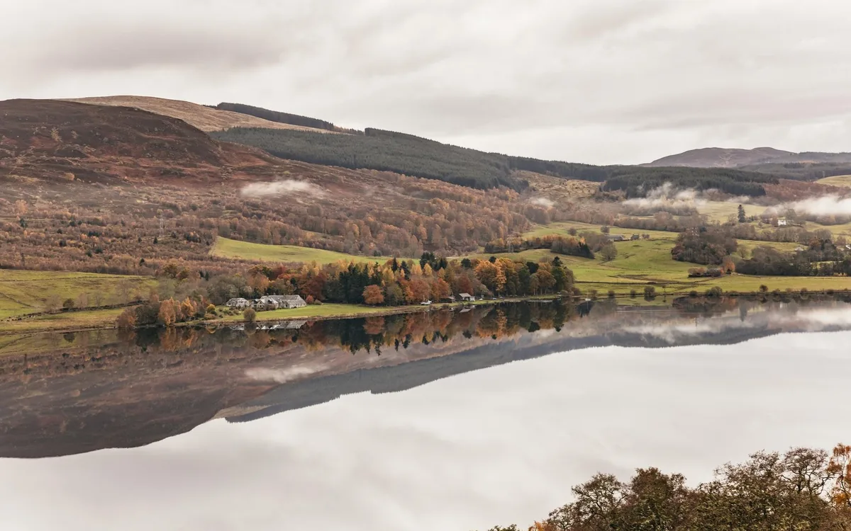 A Highland glen with heather and a single track road