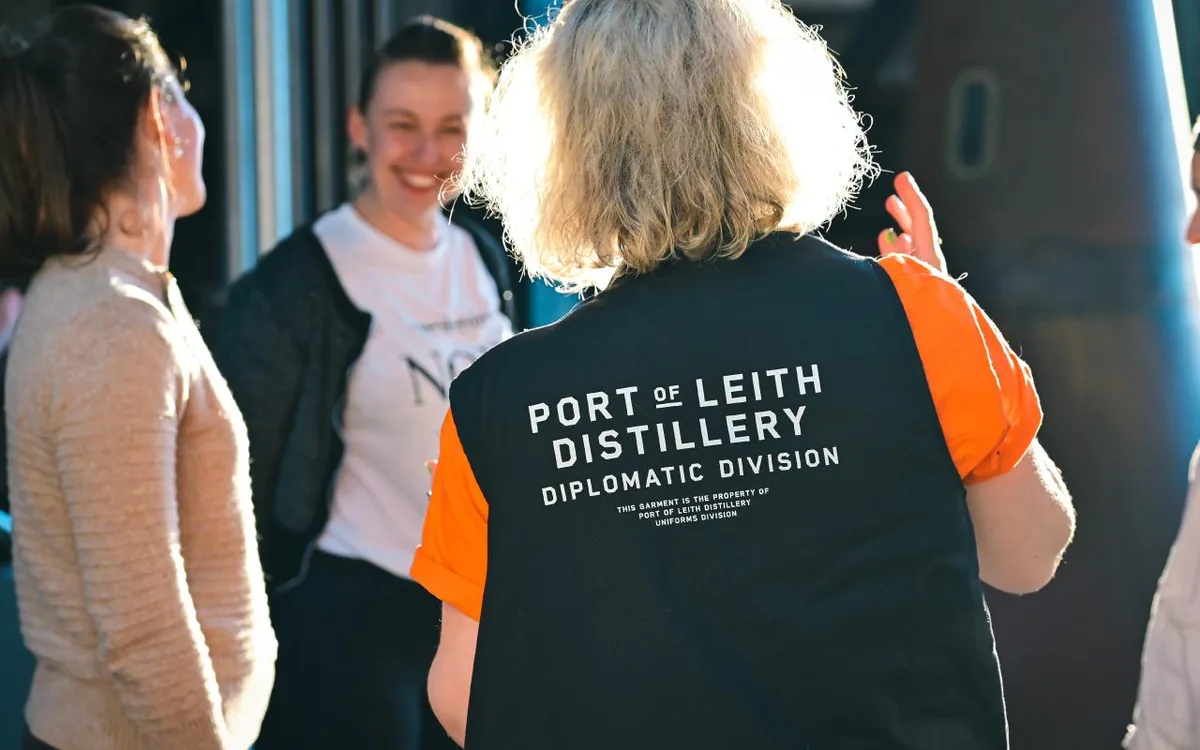 The tall glass tower of the Port of Leith Distillery above the harbour