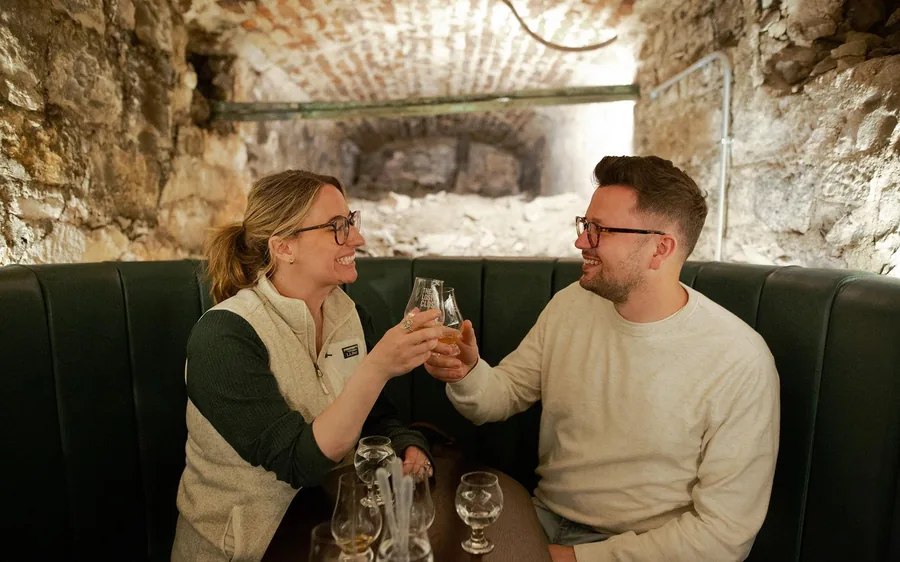 A candlelit stone vault set for a whisky tasting under the Old Town